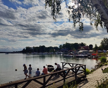 Grupa osób ciesząca się relaksem nad brzegiem jeziora